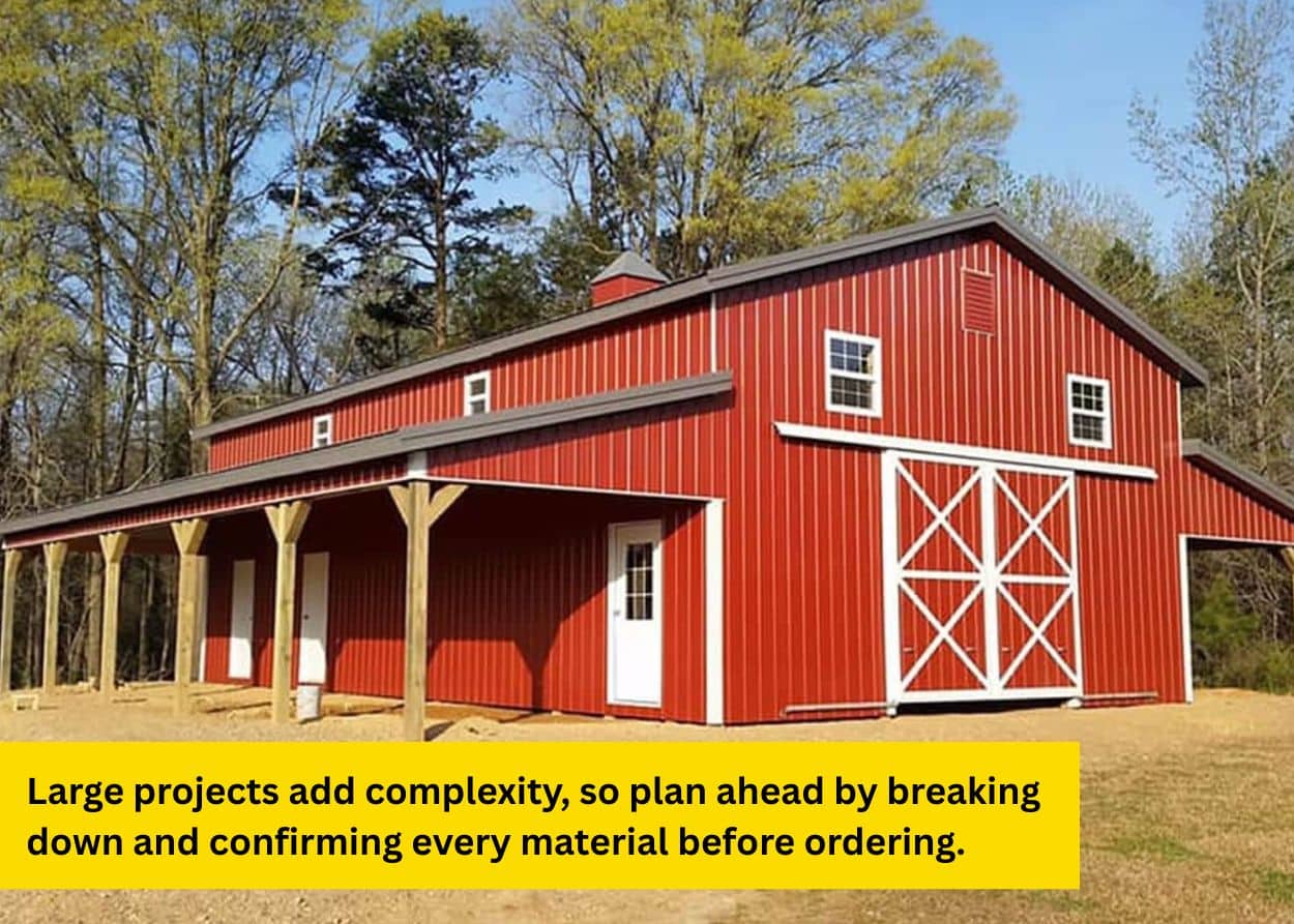 Red metal barn building with white trim and covered porch in a rural setting